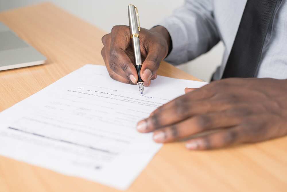 homme avec un stylo plume signant un contrat